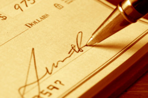 Hand signing a check, gold toned.